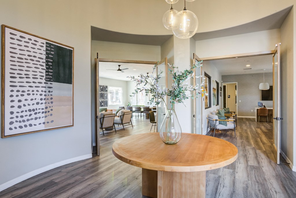 a living room and dining room with a table and a vase with flowers